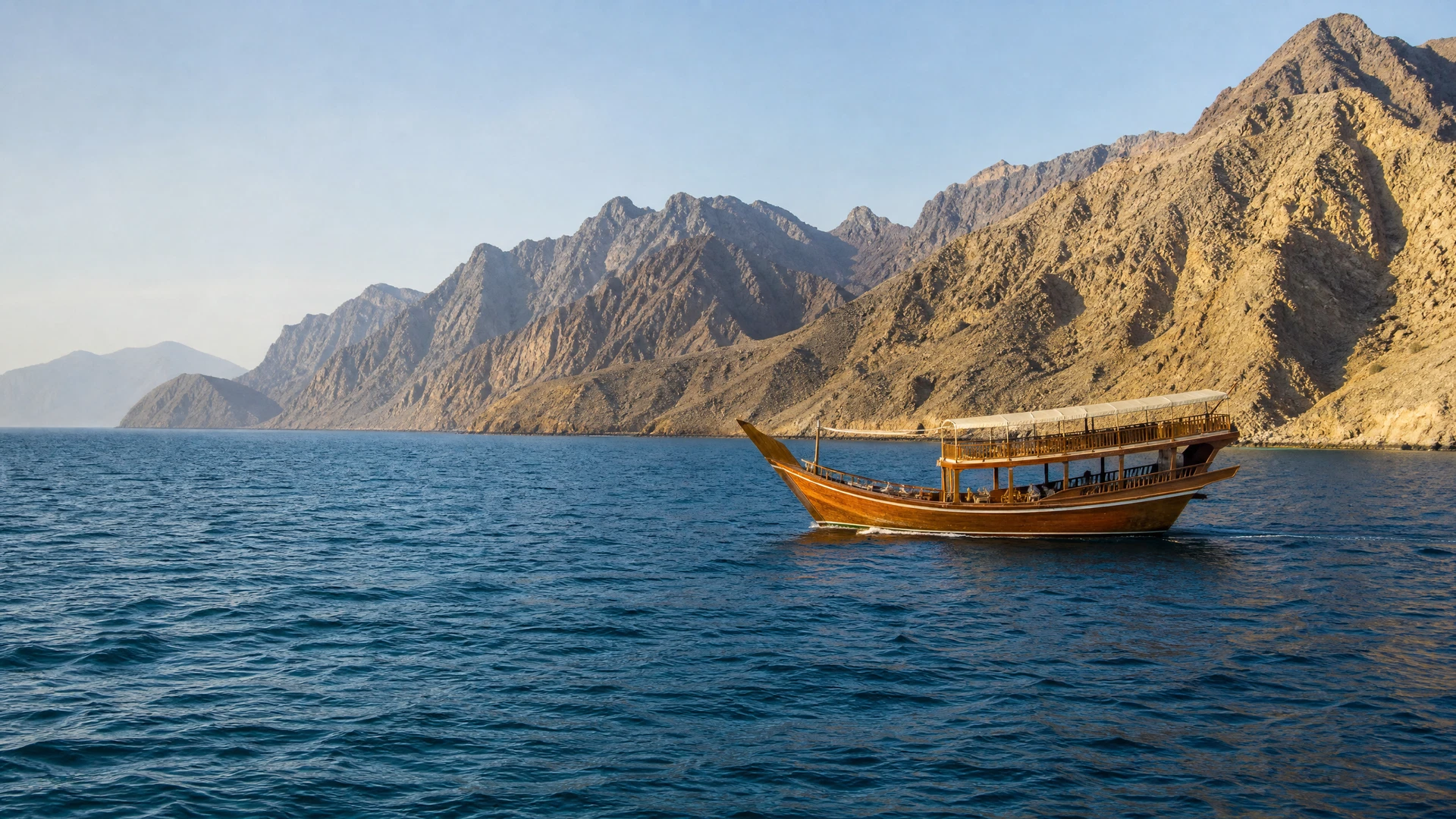 Illustrative traditional dhow on the UAE east coast near rugged mountains